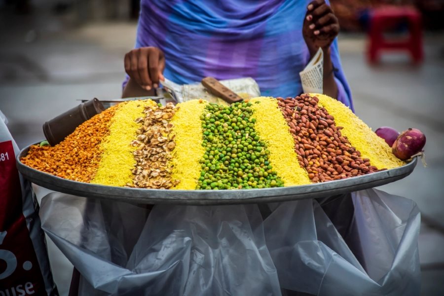 Assorted Indian savoury snack mixes displayed on a vendor tray